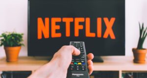 man pointing remote control at Netflix