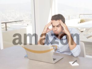 Man struggling on laptop with amazon logo faded in