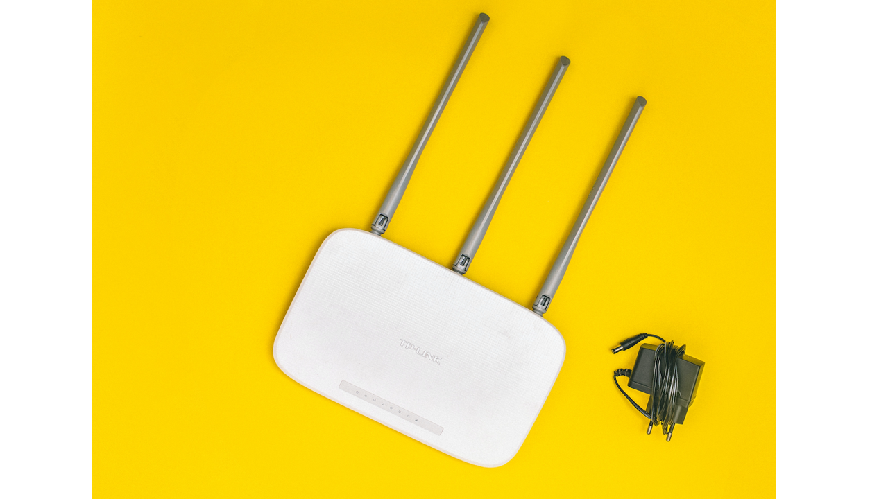 Wifi router with power cord on yellow background