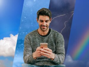 Weather forecasts in background, man smiling at phone in foreground