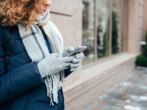 Woman using phone with gloves