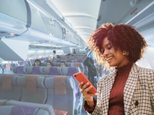 Woman smiling at phone and people sitting on flight