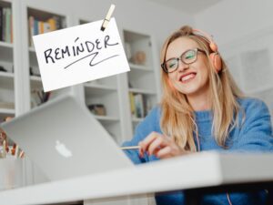 Woman smiling at Mac with reminder post it above
