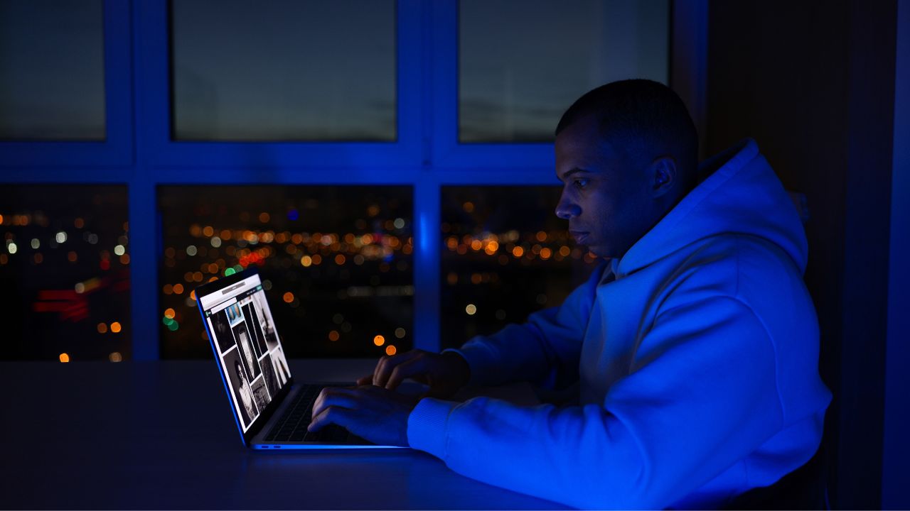 MAN ON COMPUTER AT NIGHT