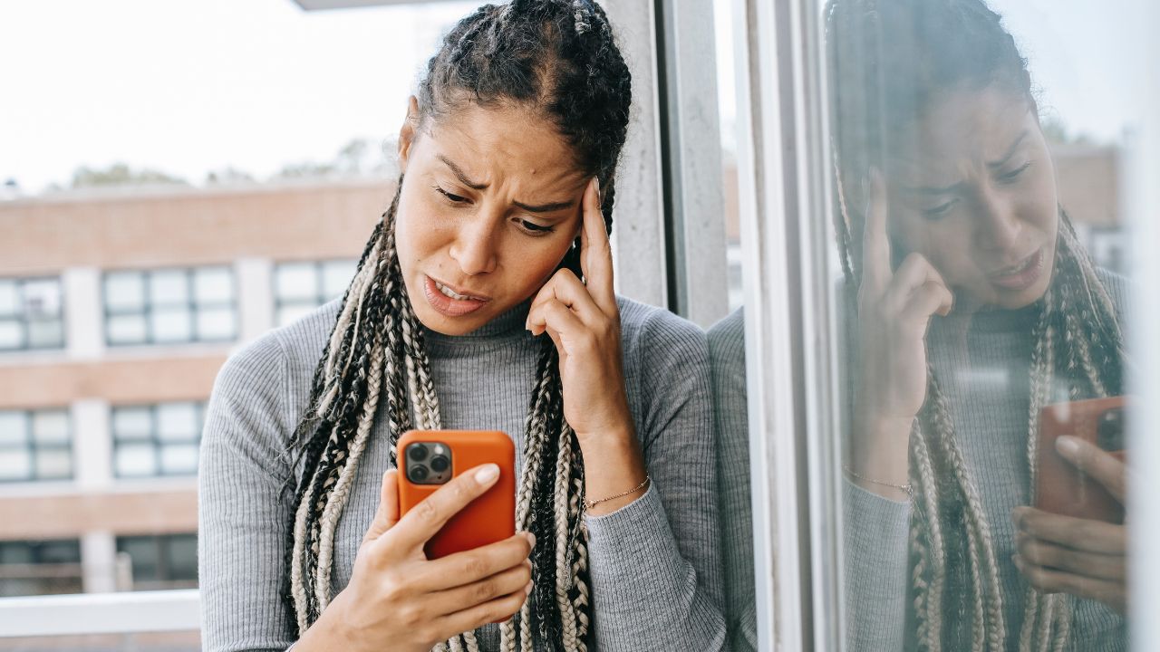 STRESSED WOMAN LOOKING AT PHONE