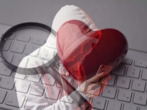 Keyboard with heart and magnifying glass with scammer lurking on phone