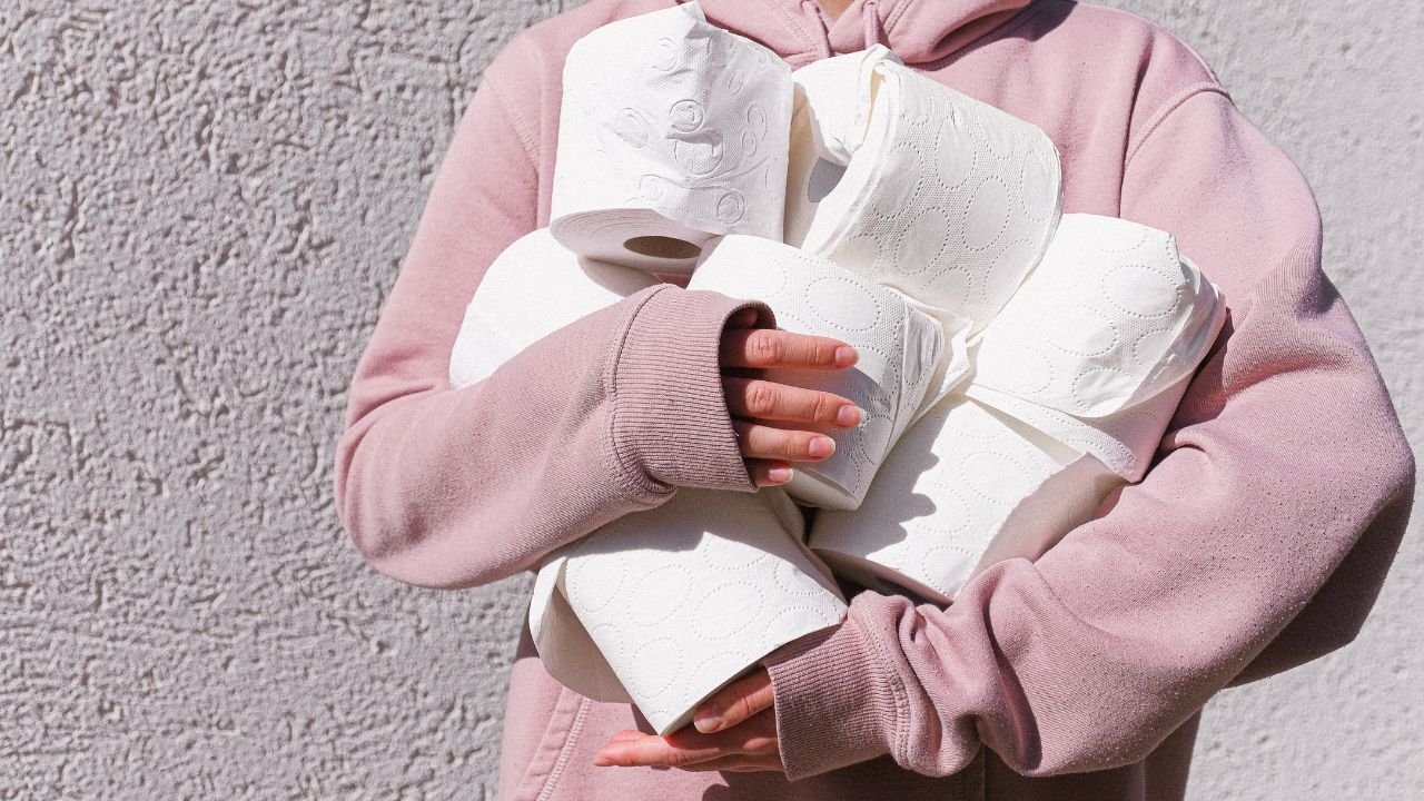 PERSON HOLDING TOILET PAPER