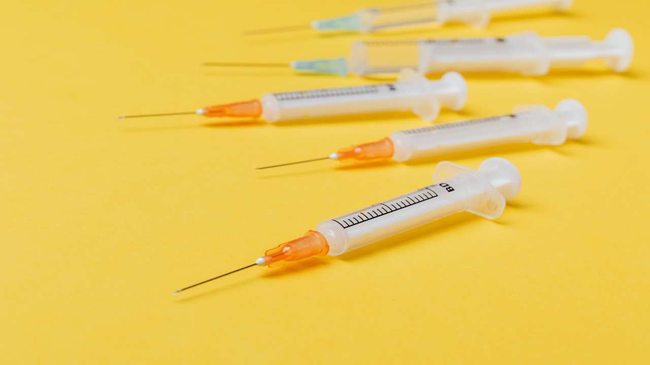 medical needles scattered on an orange floor