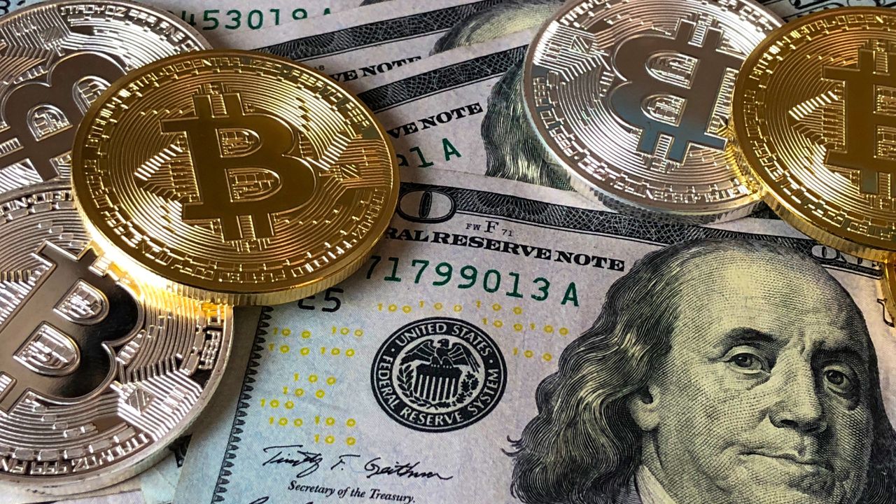 bitcoins atop of hundred dollar bills