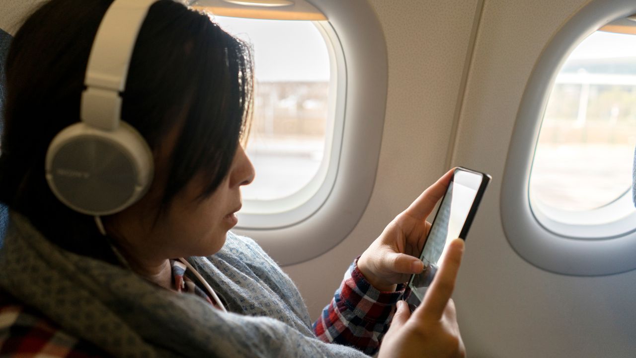 3-PERSON ON PLANE WITH PHONE