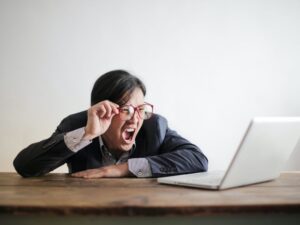 man screaming at his computer because of malware