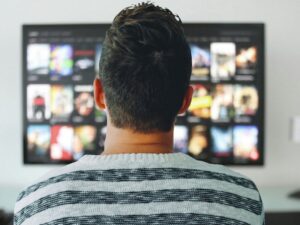 Man sitting in front of TV watching streaming content