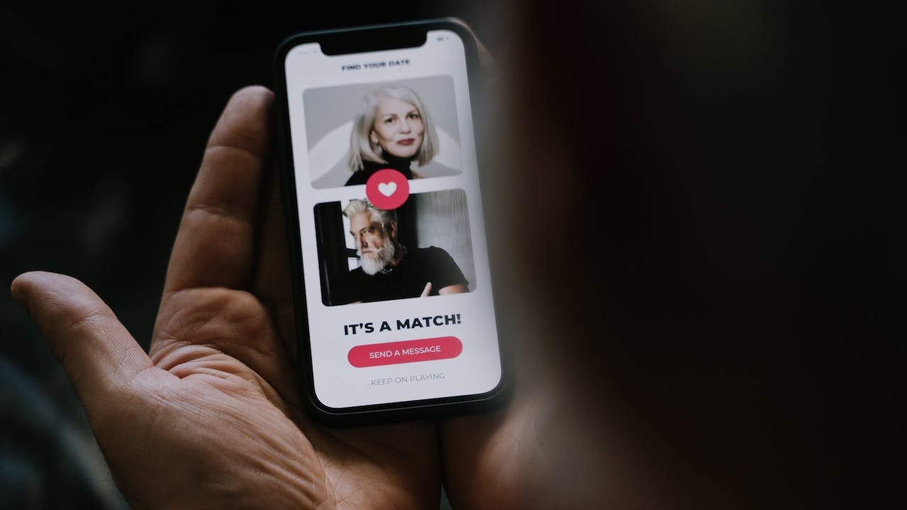 Someone holding a mobile phone showing an online dating match