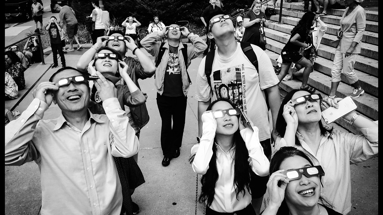 A stock photo of people enjoying a solar eclipse with eclipse glasses.