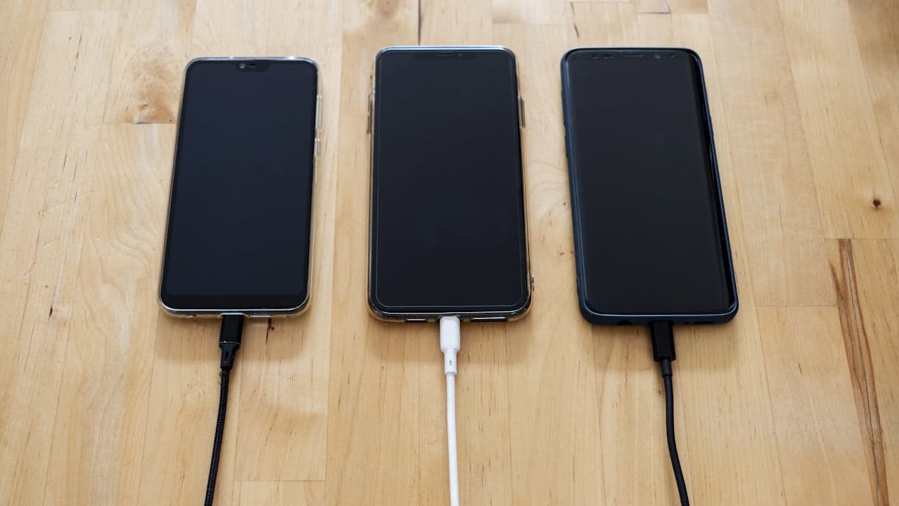 Phones charging on wooden table