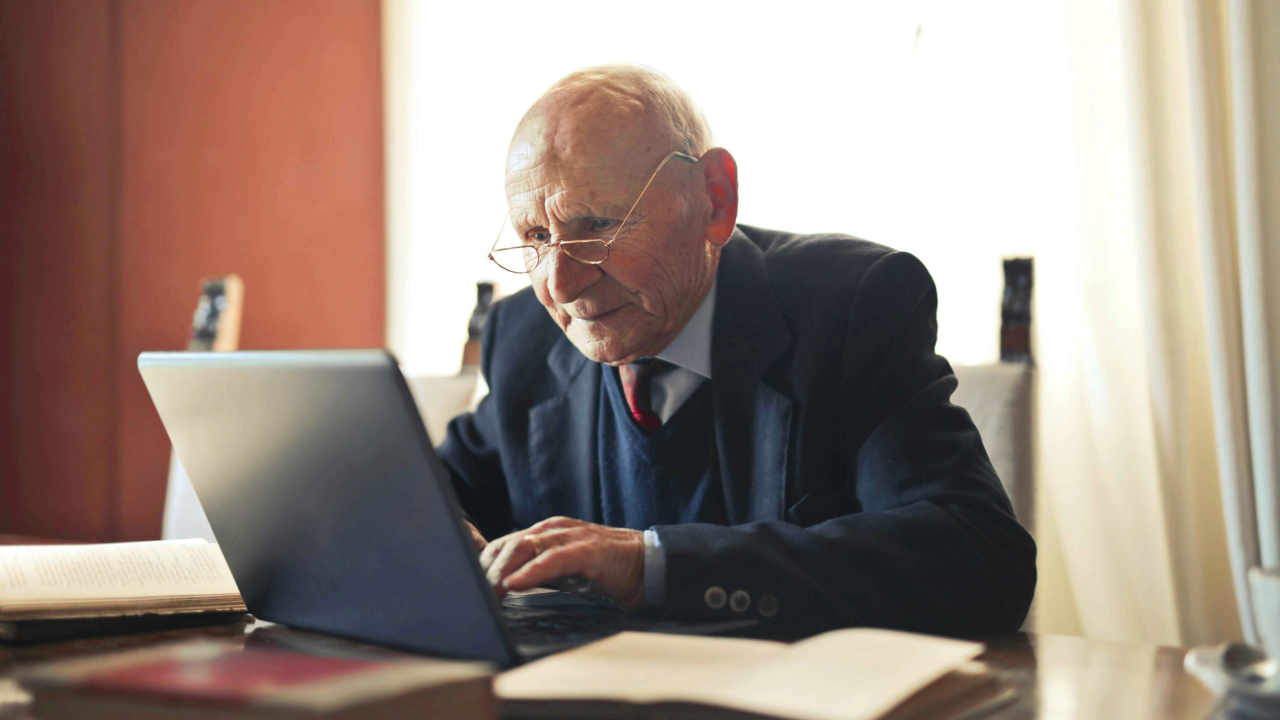 An old person in front of a laptop