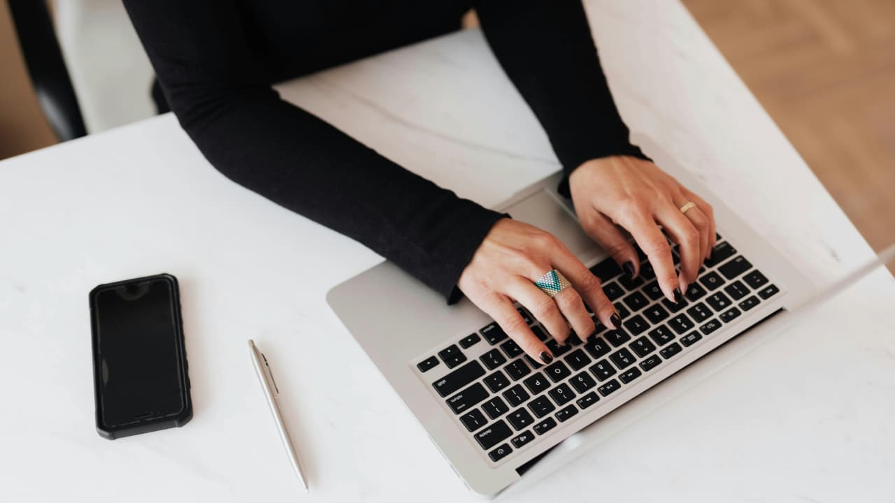 A person typing on a MacBook.