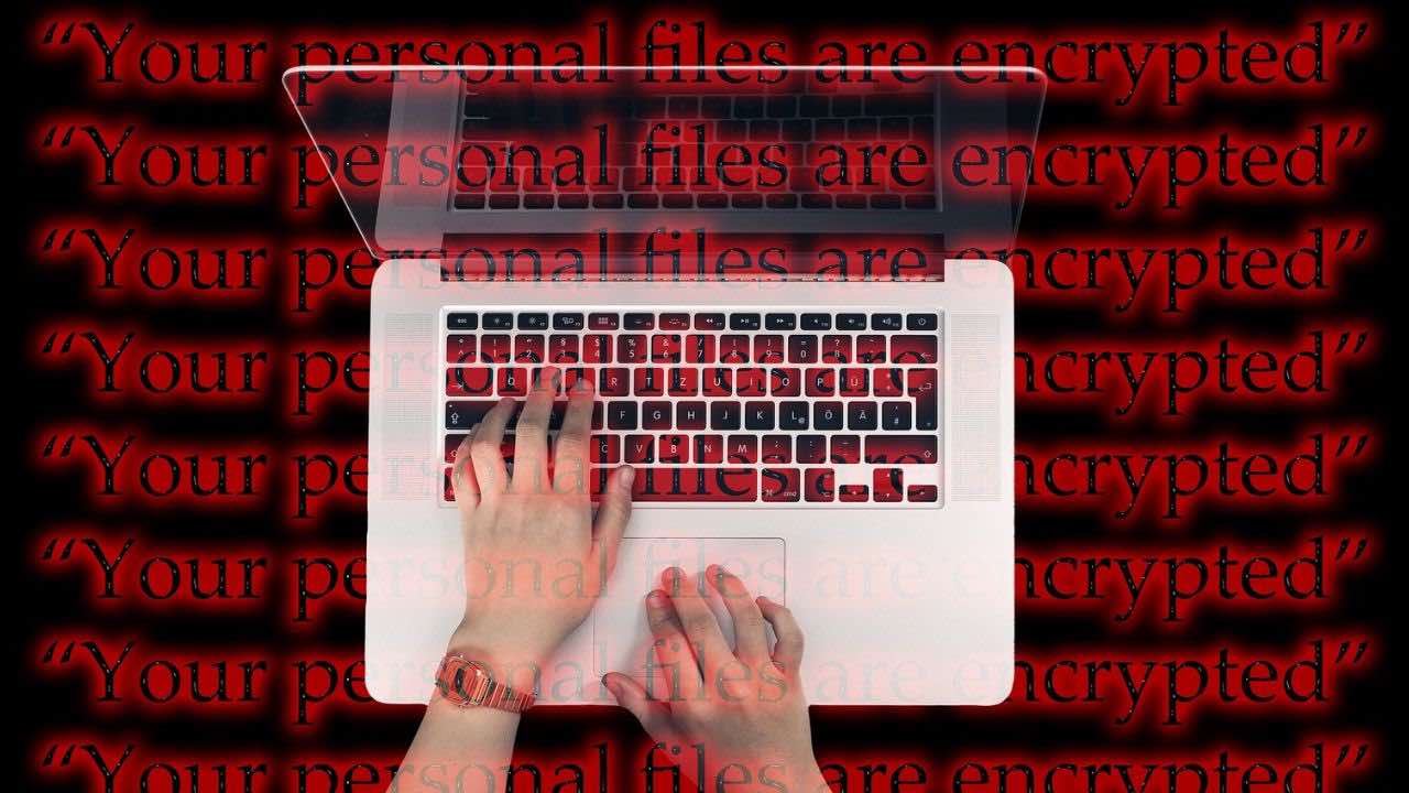a person typing on a laptop with the words your personal files are encrypted
