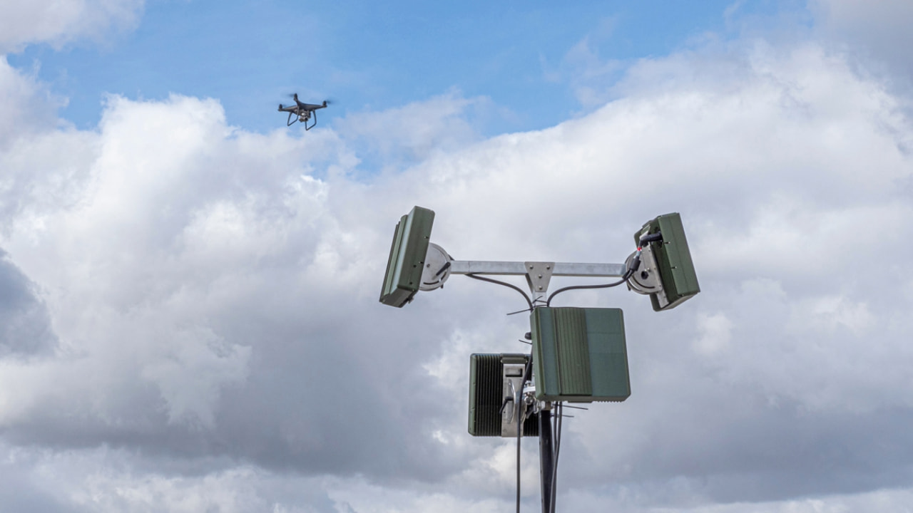 A drone detection system with a drone flying the background.