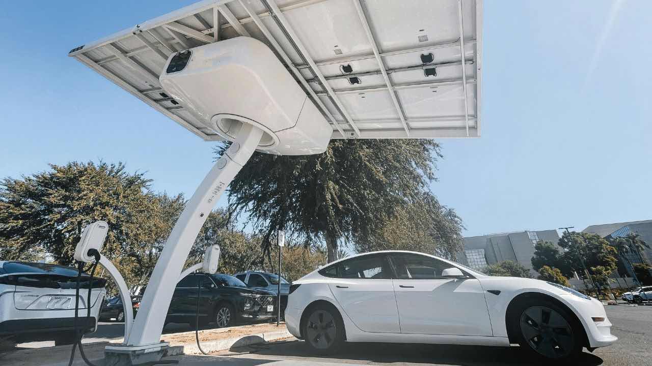 a tesla model 3 is plugged into an electric vehicle charging station