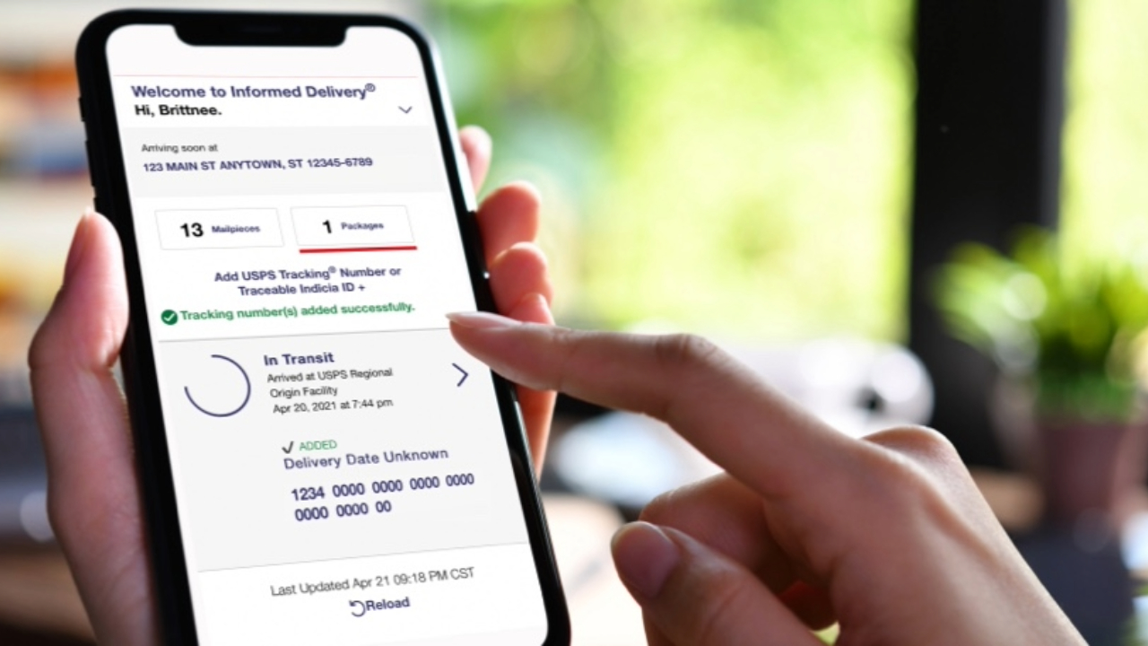 A photo from the USPS showing a hand holding an iPhone with the informed delivery app from USPS on the iPhone screen.