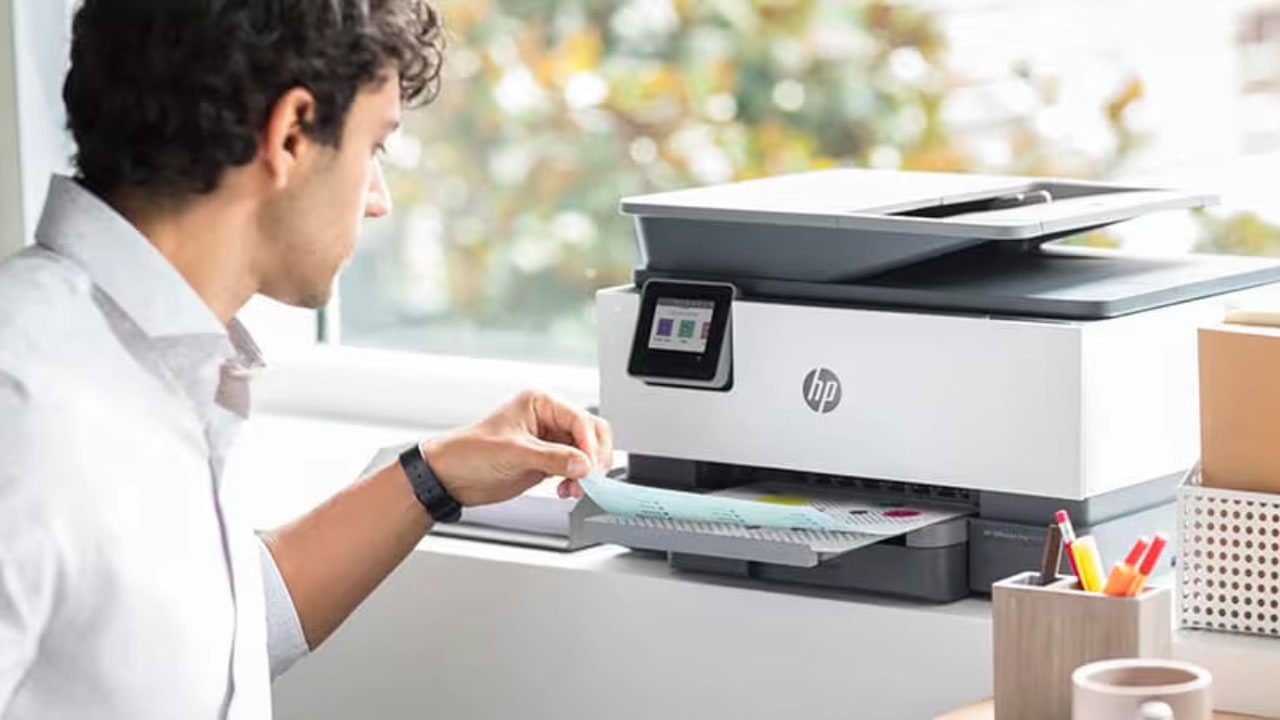 A person using an HP printer kept on a surface.