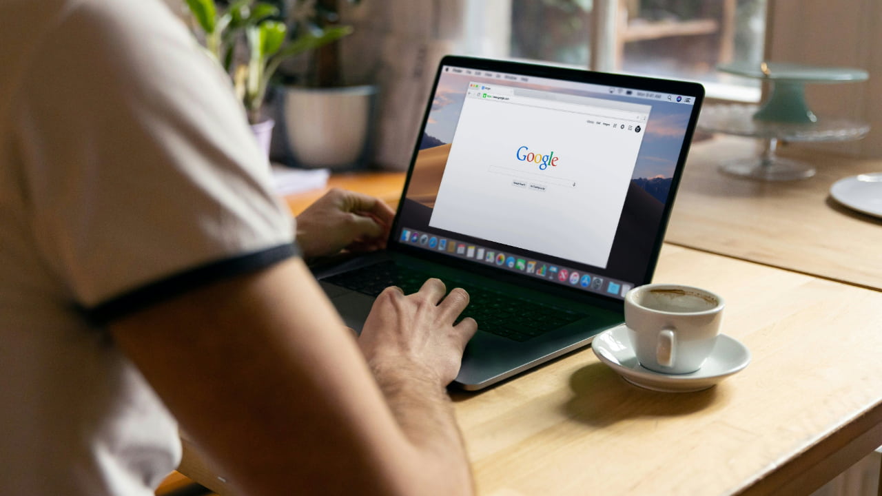 A person using a MacBook with Chrome browser open.