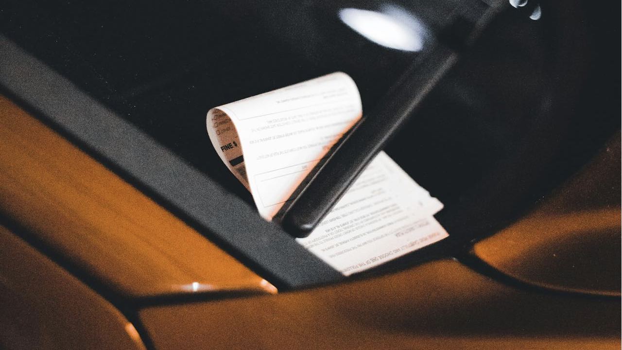 Parking ticket on yellow car's windshield