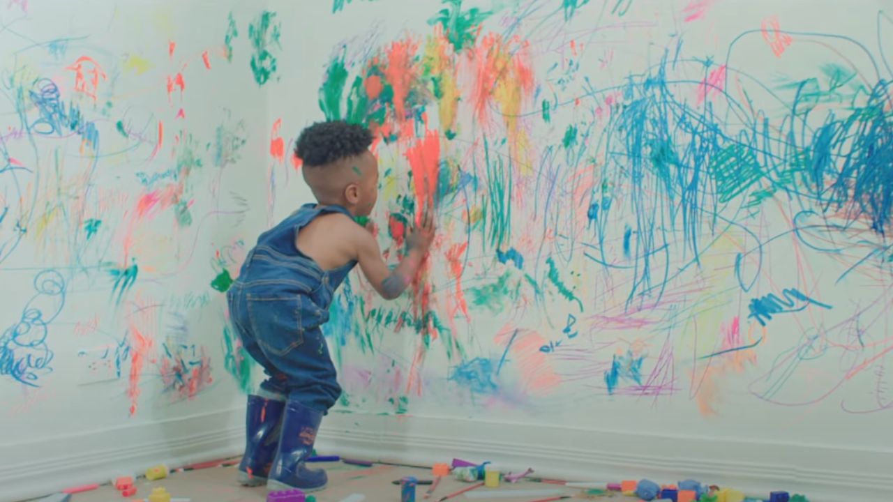 A child coloring on walls painted with peelable paint 