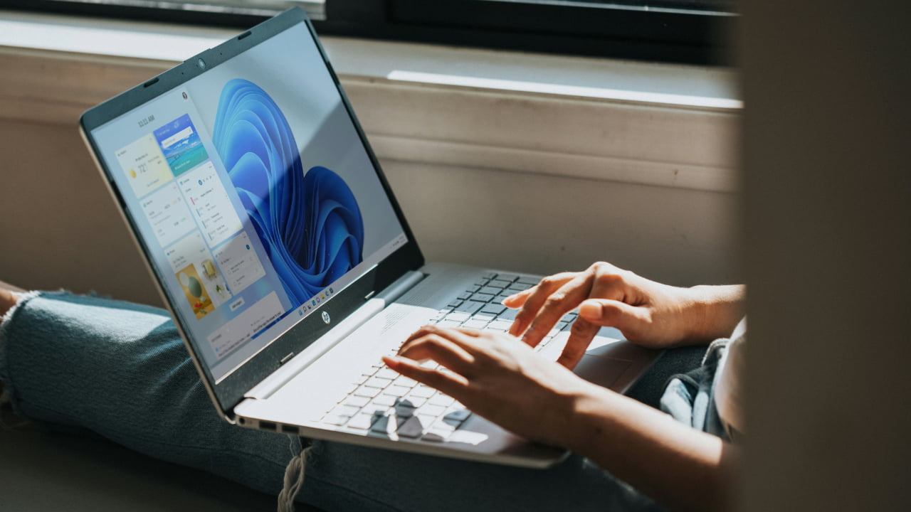 A person typing on a Windows laptop.