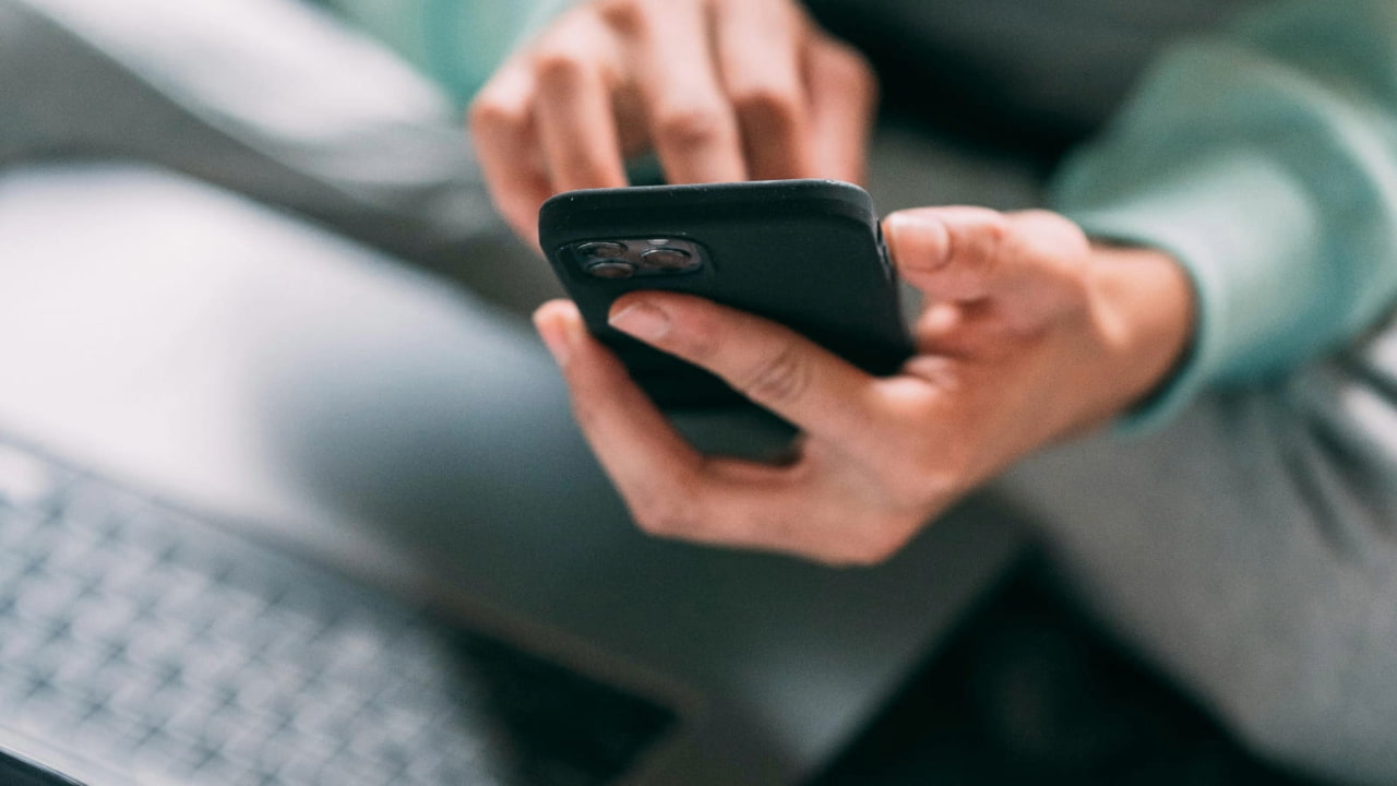 A person holding a smartphone in their hand.