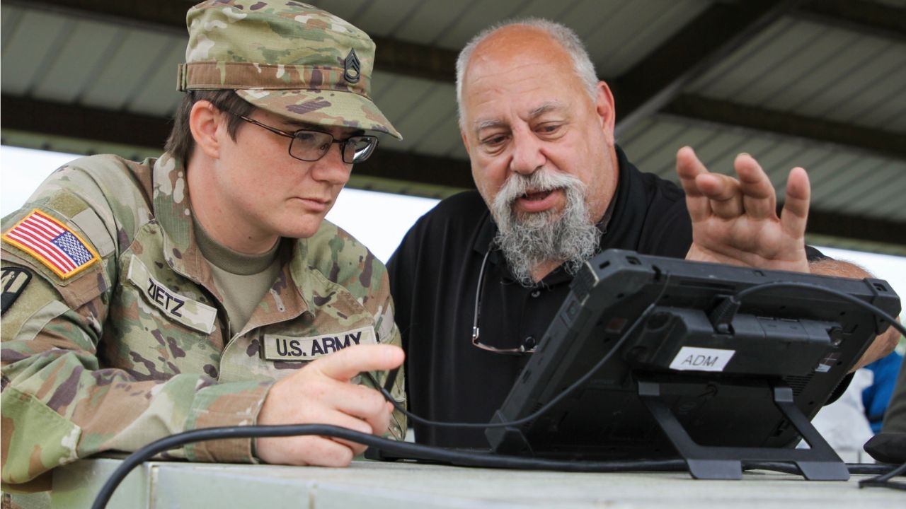 Image of two individuals looking at the screen of Image of an Autonomous Equipment Decontamination System