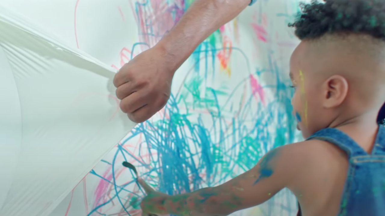 A child pulling off peelable paint from the wall 