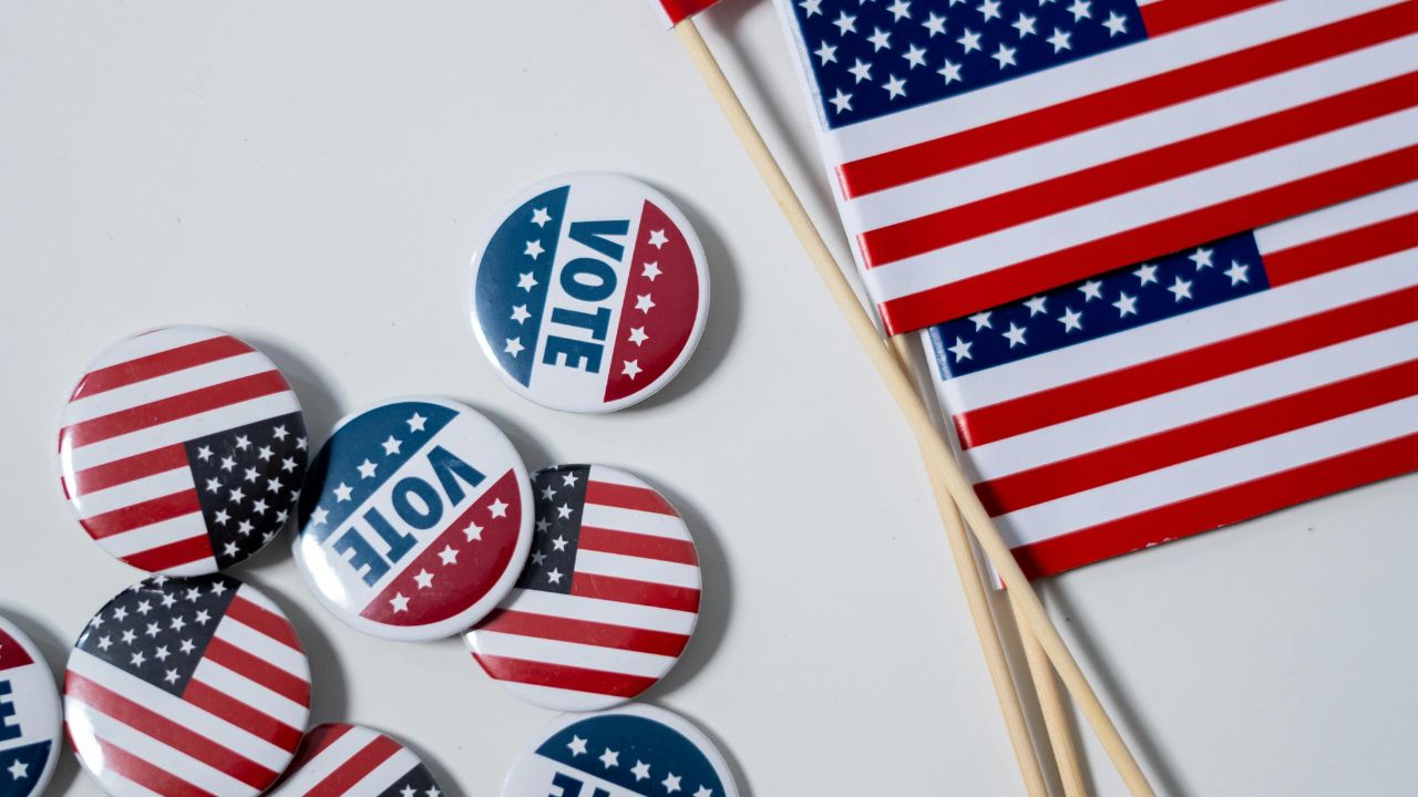 Election promotional materials including badges, and the US flag.