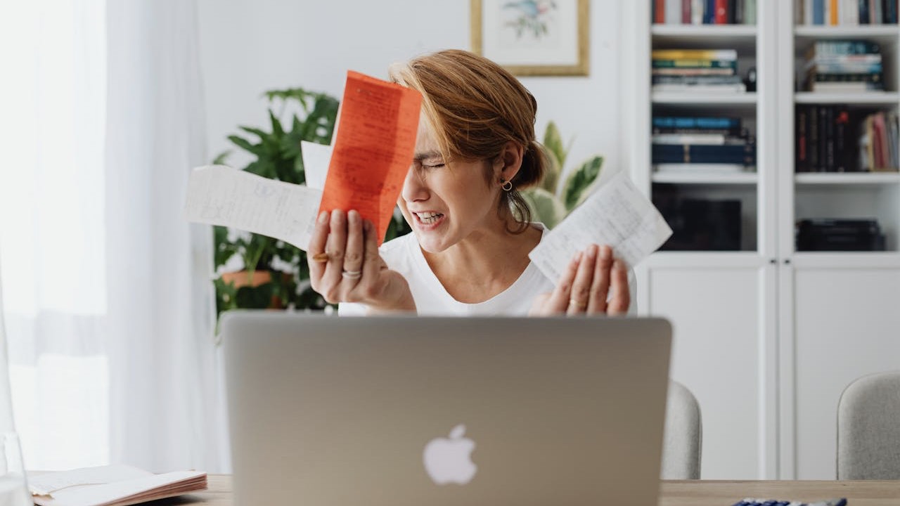 Woman Crying while Holding Bills in her Hands