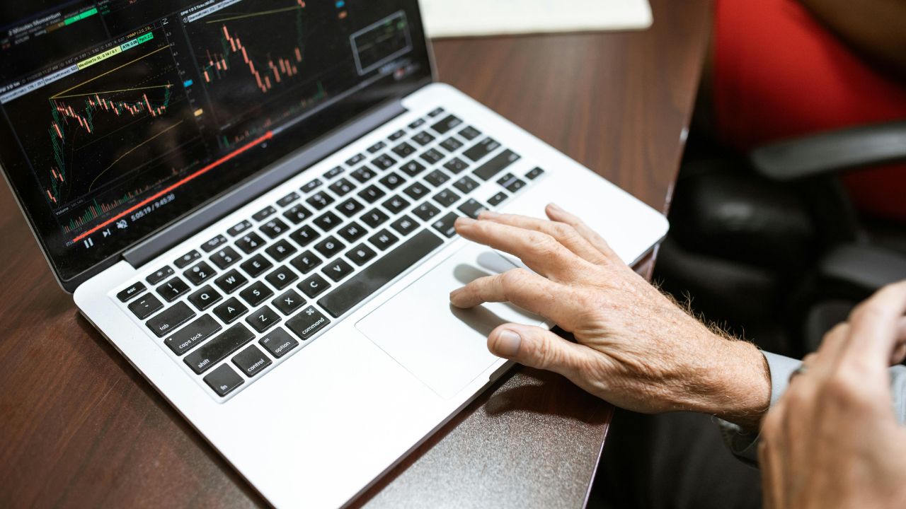 Image of a stock trader typing on a laptop 