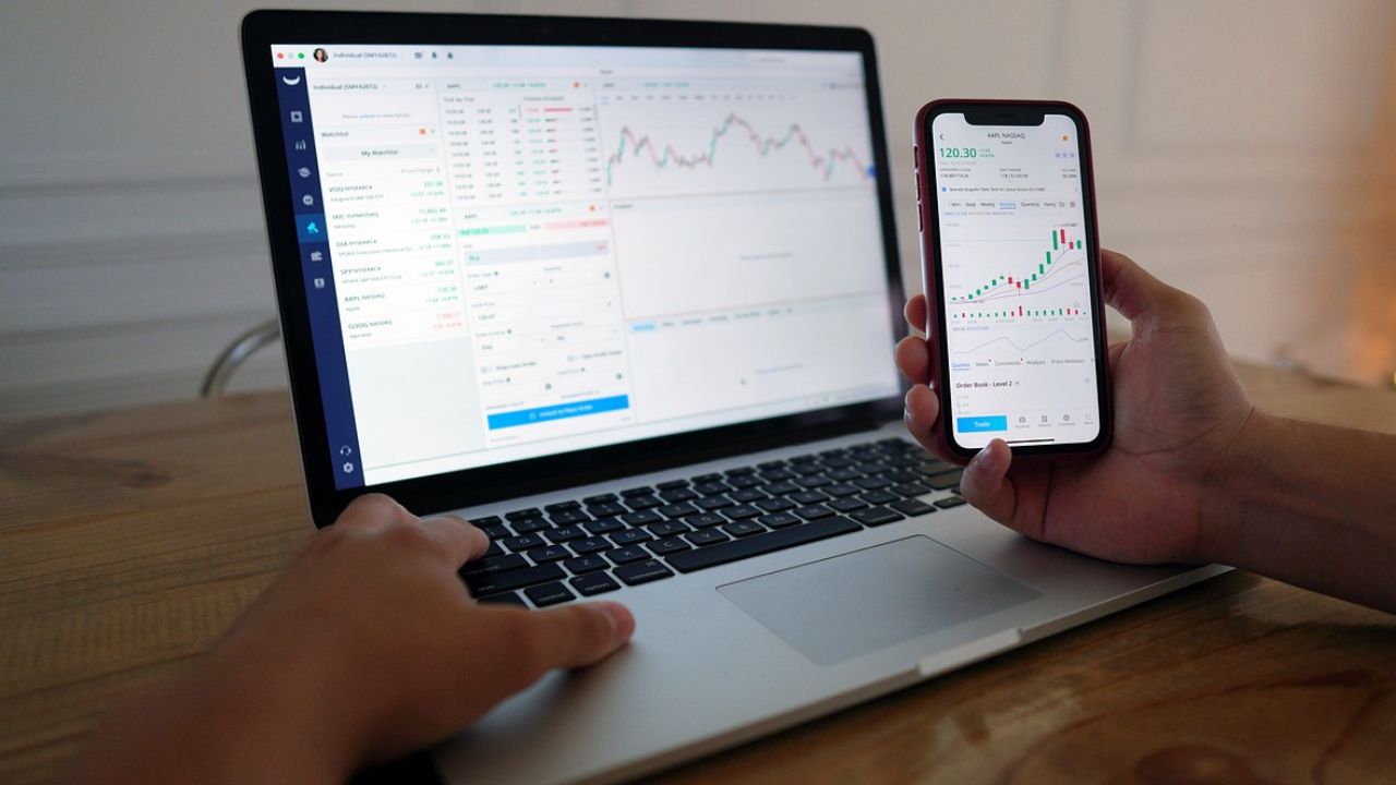 A stock broker working on his laptop and cell phone 