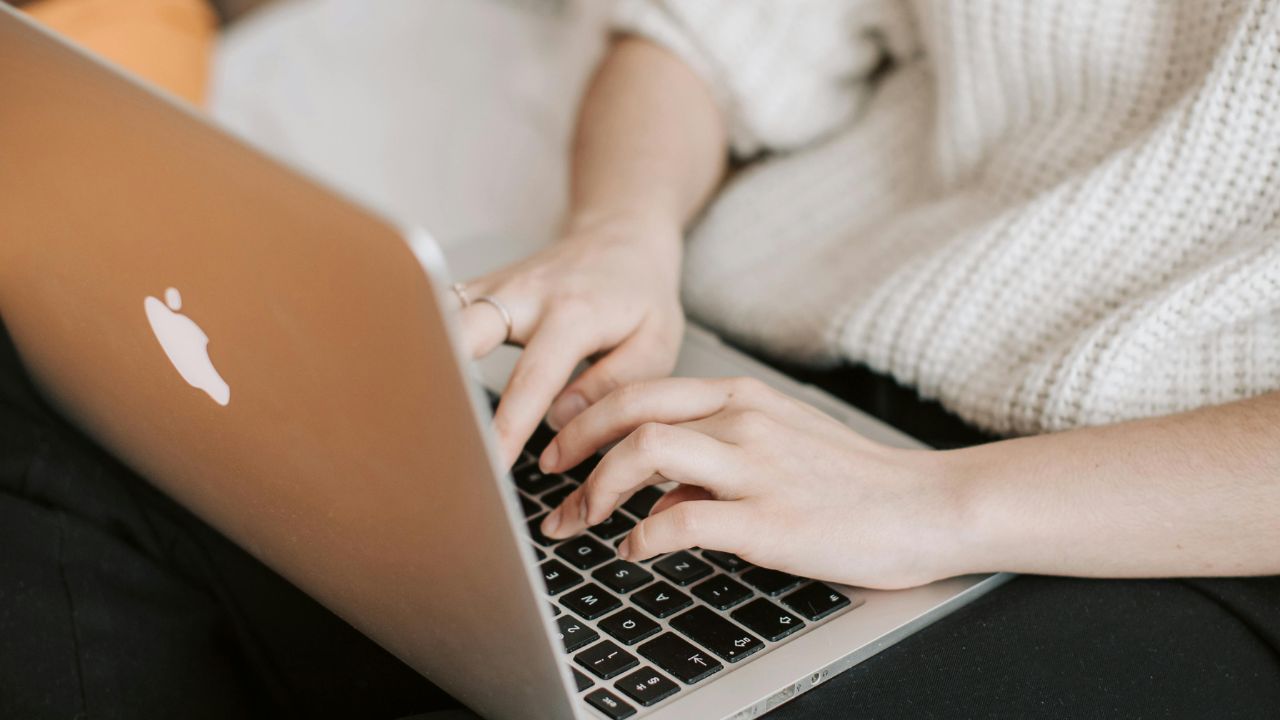 A person typing on a Macbook