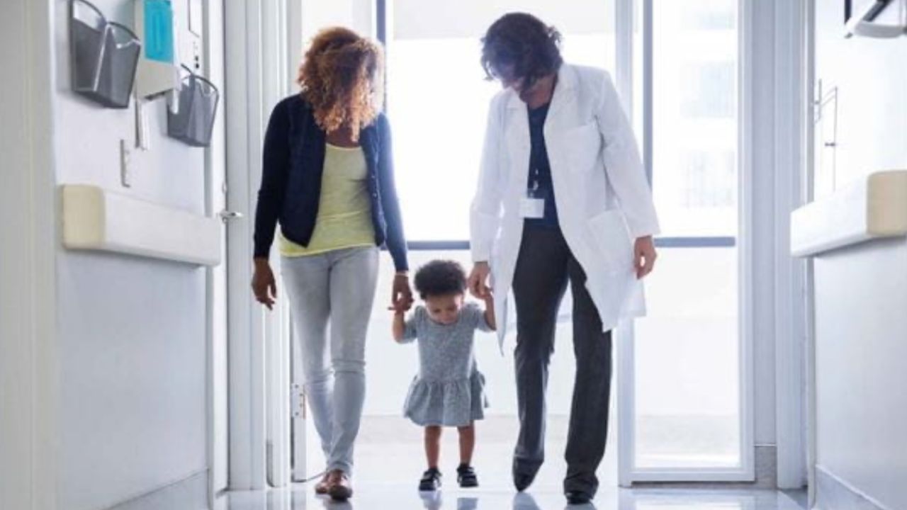 Doctor helping a child walk