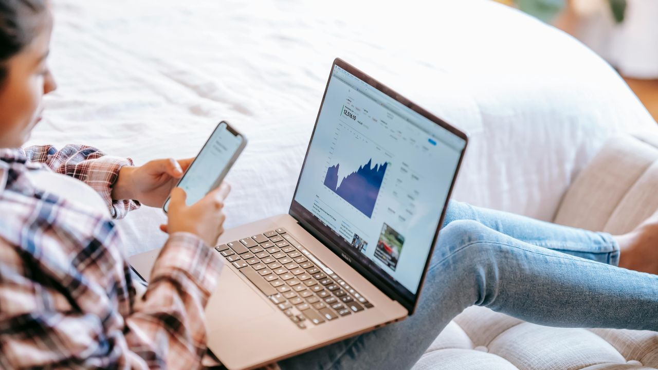 A woman using a VPN on her cell phone and laptop 