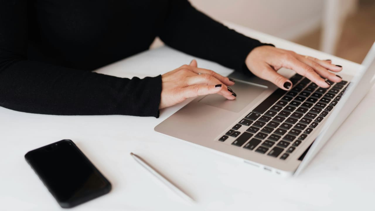 A person typing on a Macbook