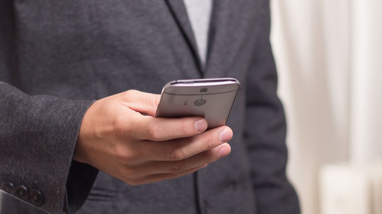 Image of a man texting on his phone 