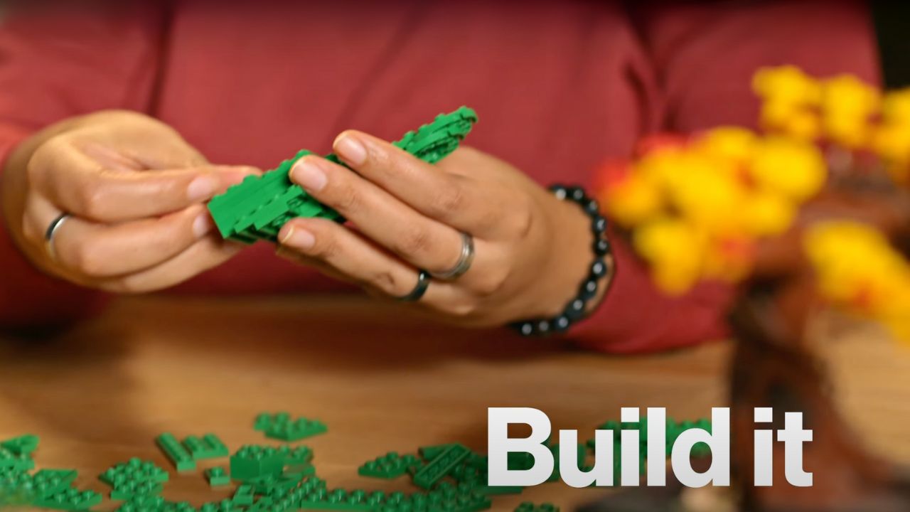 A woman using Legos to build a creation 