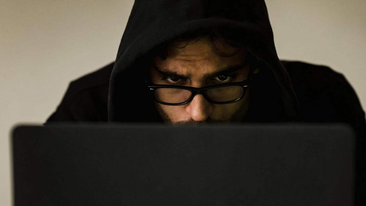 A stock photo of a man staring intently at a laptop. 