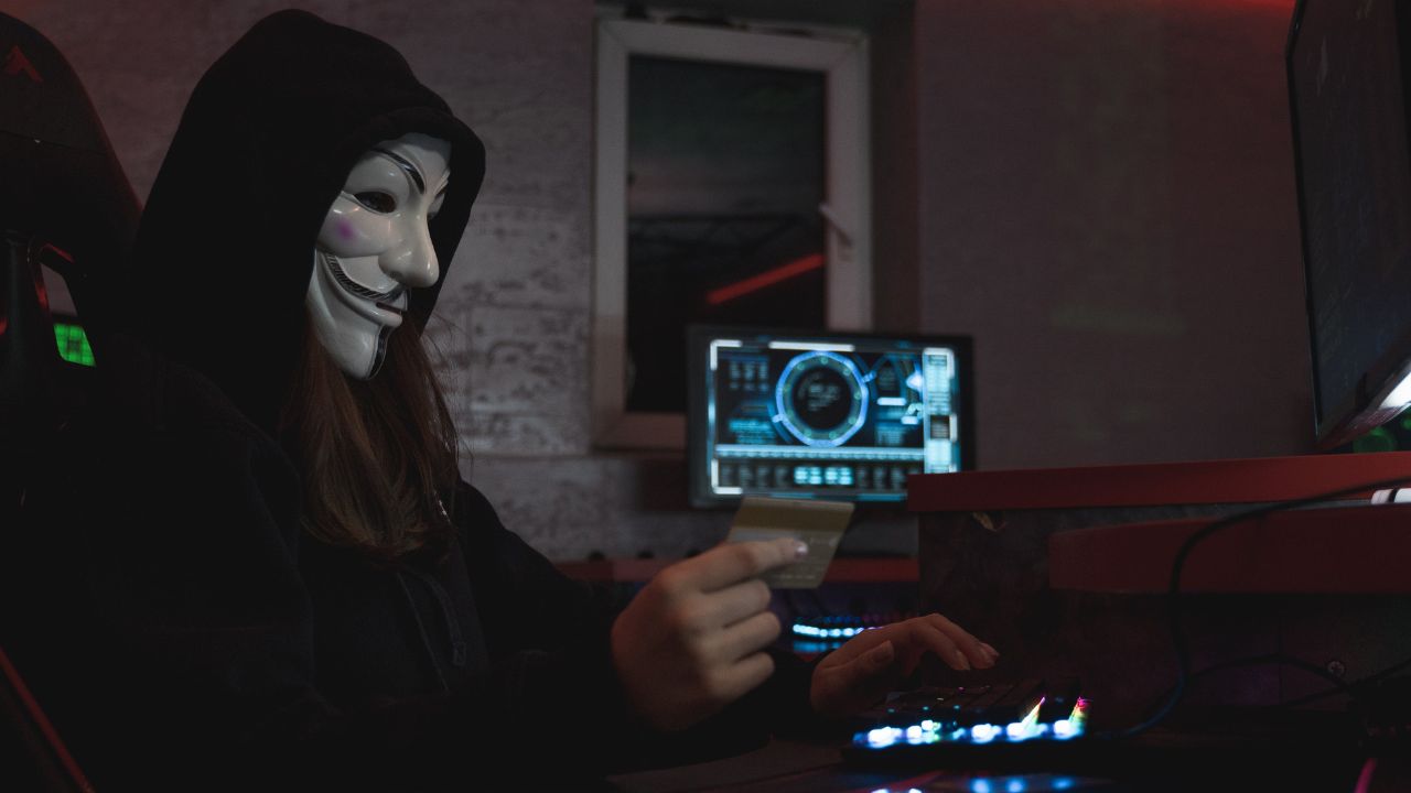 A person is wearing a mask and using computer