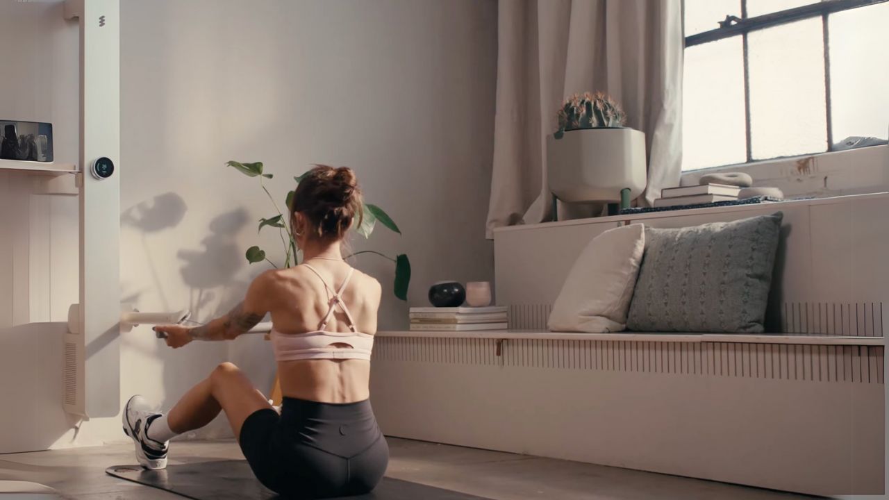 A woman sitting on the ground in her living room.