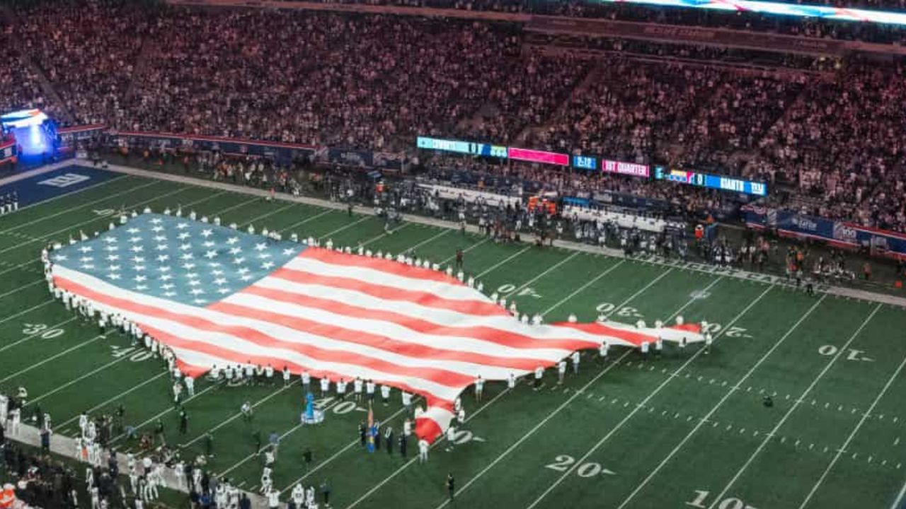 Image of u.s. flag on the football field 