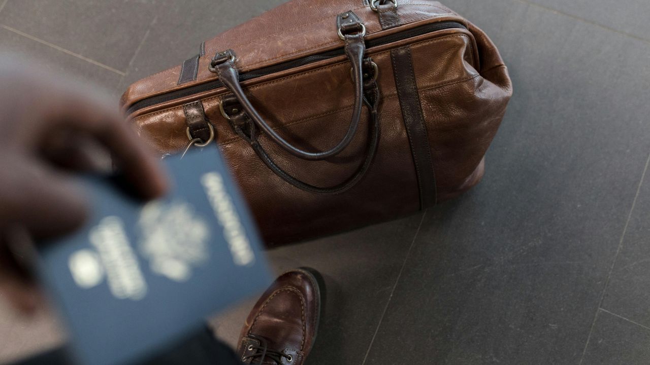 A man holding his passport while traveling 