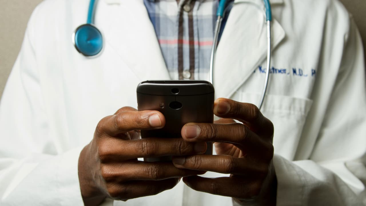 A doctor is using a smartphone