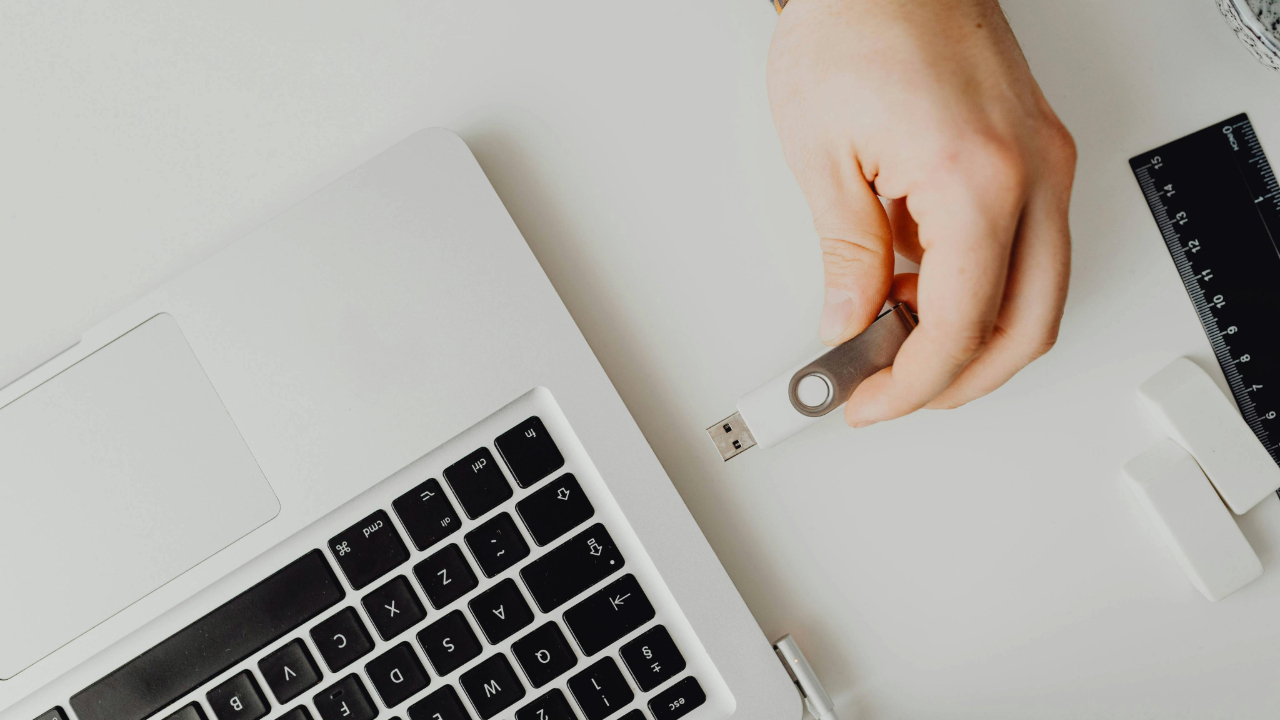 A stock photo showing a USB flash drive being inserted into a laptop.